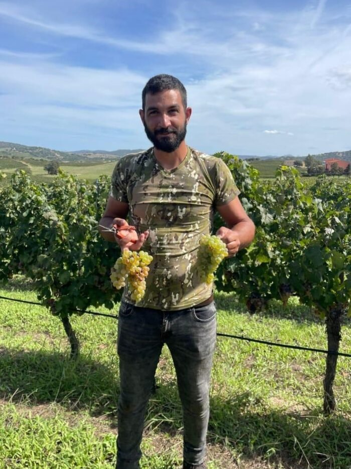 Antonio Satta che tiene l'uva bianca in mano